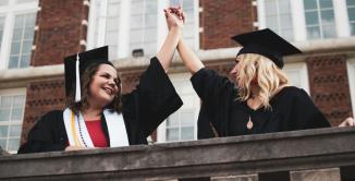 Zwei Frauen die bei einer Ausbildungsabschlussfeier high five abklatschen als Symbolbild fuer das Training: Nutanix Advanced Administration and Performance Management (AAPM) v6.10